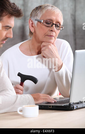 Donna anziana utilizzando un computer Foto Stock