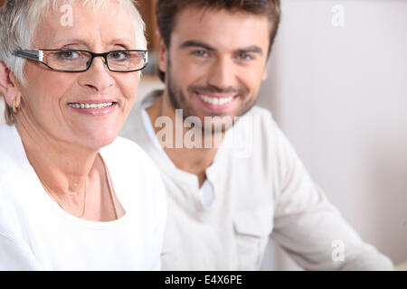 Senior donna seduta con un giovane uomo Foto Stock