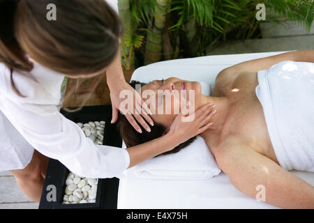 Donna avente testa massaggiato Foto Stock