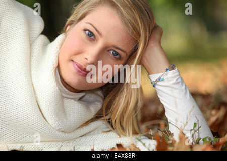 Donna disteso in una foresta autunnale Foto Stock