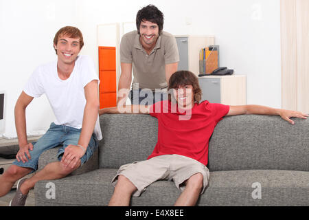 Tre ragazzi in un momento di relax a casa Foto Stock