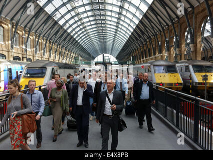 I passeggeri che arrivano fuori il treno alla stazione di King Cross, Londra Foto Stock