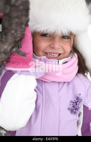 Felice bambina giocare nella neve Foto Stock