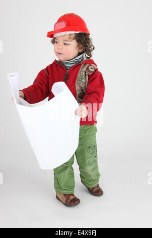 Little Boy vestito come builder di piani di contenimento Foto Stock