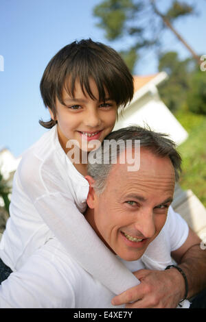 Papà dando figlio piggyback Foto Stock