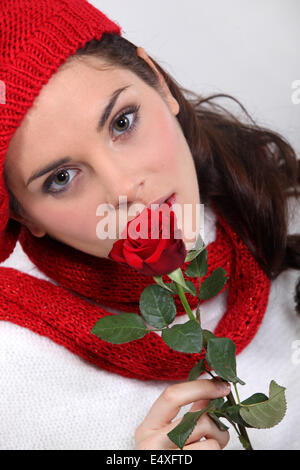 Donna che mantiene una rosa rossa Foto Stock