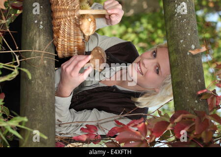 La donna la raccolta di funghi nei boschi Foto Stock