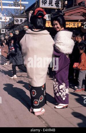 Due geishe in abito tradizionale in un mercato di strada, Tokyo 1961. Foto Stock