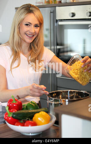 Sorridente casalinga che prepara la pasta Foto Stock