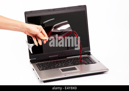 Vino versato sul computer portatile Foto Stock