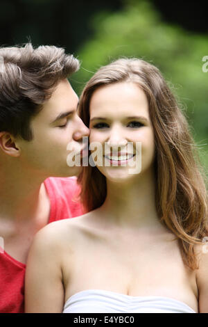 Ragazzo adolescente baciando la sua bella ragazza Foto Stock