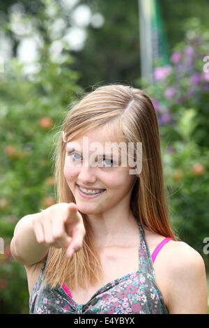 Felice ragazza adolescente puntando verso la telecamera Foto Stock