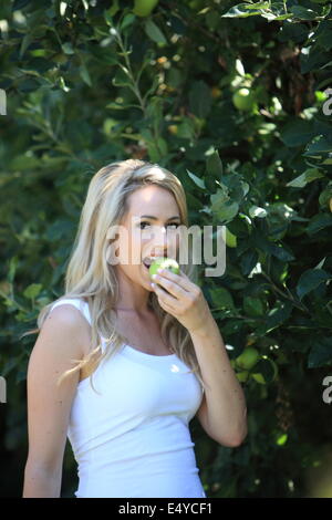 Giovane donna di mangiare una mela verde Foto Stock