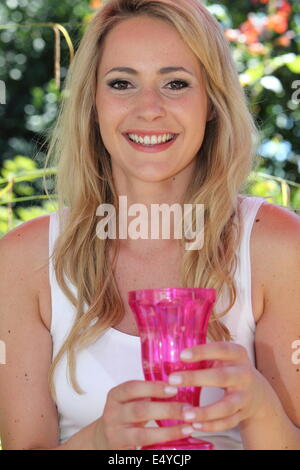 Sorridente giovane donna tenendo un vaso Foto Stock