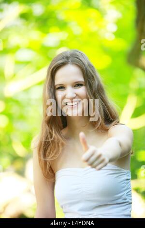 Felice giovane donna dando un pollice in alto Foto Stock