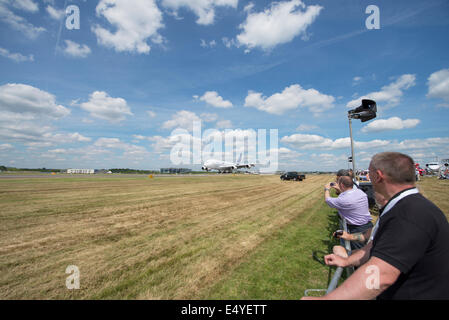 Aerodromo di Farnborough Hampshire, Regno Unito. 17 luglio 2014. Il salone aerospaziale internazionale è il Regno Unito il più grande evento nel settore aerospaziale e della difesa, del calendario che si tiene ogni due anni. Fornire opportunità di affari per l'industria aerospaziale globale si apre anche al pubblico il 19-20 luglio, quest'anno celebra i suoi cento anni di storia dell'aviazione. Aeromobili partecipanti raggiungono un nuovo alto per Farnborough International Airshow di quest'anno, sponsorizzato dal gruppo di Airbus. Linea di spettatori la pista a guardare il gigante Airbus A380 terra, il giorno 4 del Trade Show. Credito: Malcolm Park editoriale/Alamy Live News. Foto Stock