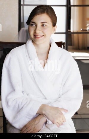 Donna sorridente in accappatoio Foto Stock