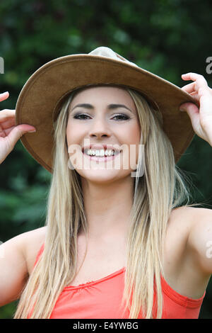 Felice giovane donna in una vasta colmato hat Foto Stock