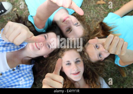 Felice quattro ragazze adolescenti dando Thumbs up Foto Stock