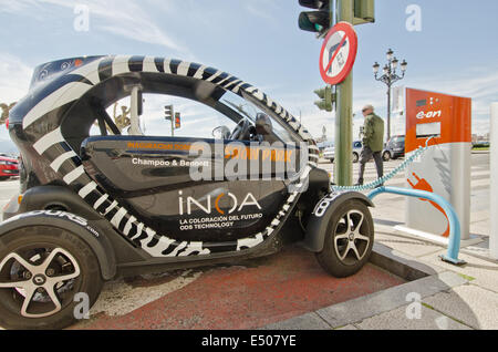 Una Renault Twizy auto elettrica ottiene la sua batteria ricaricata in un E.on street sul lato della stazione di ricarica sul lungomare di Santander Foto Stock