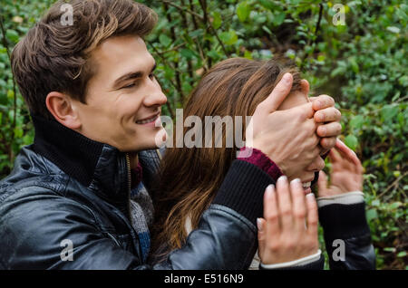 Uomo che copre Occhi di donna in posizione di parcheggio Foto Stock