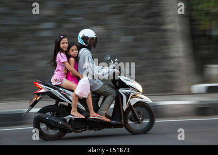 Bali, Indonesia. Donna e ragazze su Moto, Klungkung, Semarapura. Foto Stock