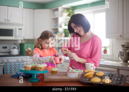 La donna come decorare le tortine con la ragazza (4-5) Foto Stock