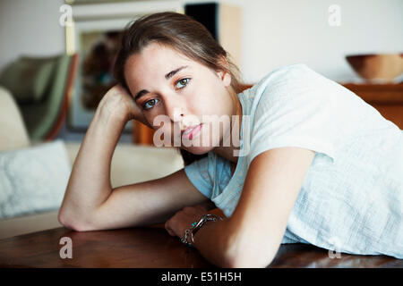 Giovane donna posa sul tavolo Foto Stock