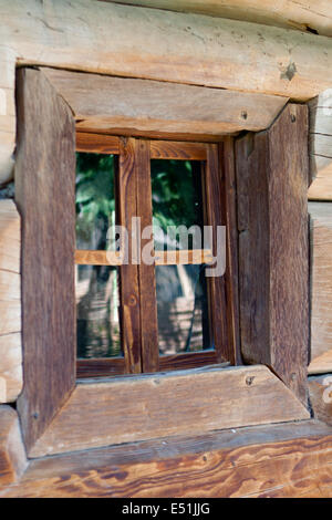 Finestra nella parete di una vecchia casa in legno Foto Stock