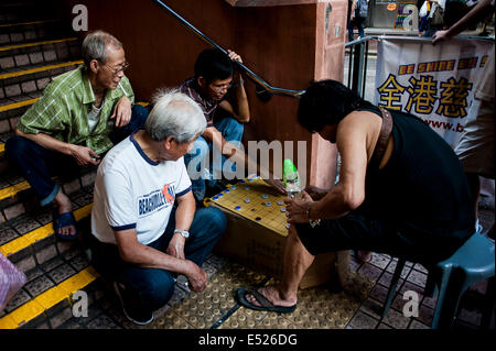 Gli uomini GIOCA Mahjong sulle strade del quartiere di Mongkok in Hong Kong Foto Stock