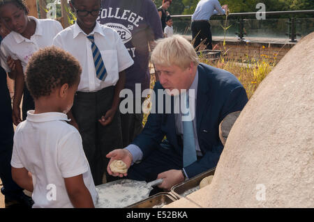 Lambeth, Londra, UK, 18 luglio 2014. Boris Johnson, sindaco di Londra e Henry Dimbleby, fondatore della Leon di ristoranti, visita la Chiesa di Cristo la scuola primaria, Lambeth per colazione, la promozione di prodotti alimentari sani. Hanno incontrato gli studenti, i genitori e gli insegnanti su un banco di scuola della outdoor aree di apprendimento tra cui un campeggio fuoco dove il pane è stato cotto da parte di alunni e di un forno a legna dove una sana prima colazione era cucinato. Credito: Stephen Chung/Alamy Live News Foto Stock