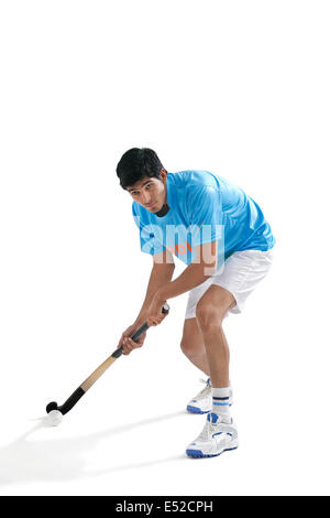 Concentrate l uomo giocare ad hockey isolate su sfondo bianco Foto Stock