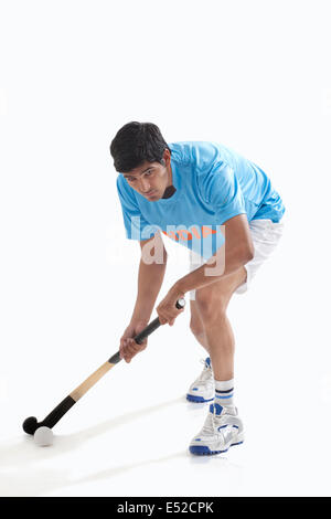 Uomo in sportswear giocare ad hockey isolate su sfondo bianco Foto Stock