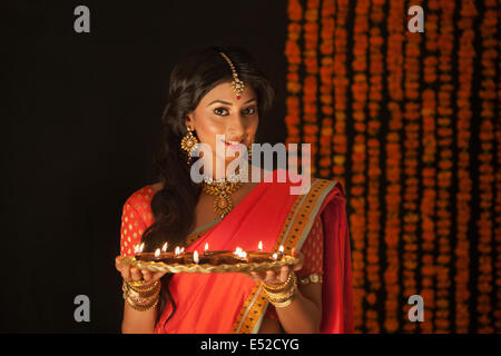 Ritratto di una donna che tiene un vassoio di diyas Foto Stock