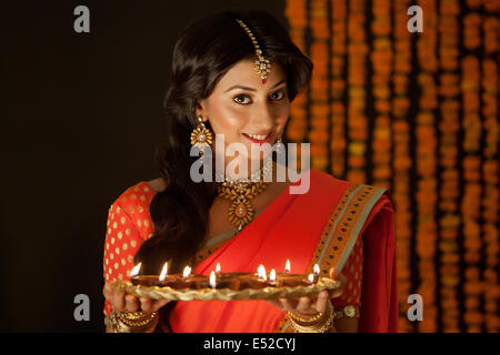 Ritratto di una donna che tiene un vassoio di diyas Foto Stock