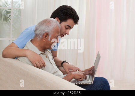 Nipote nonno di insegnamento come funziona il computer portatile Foto Stock