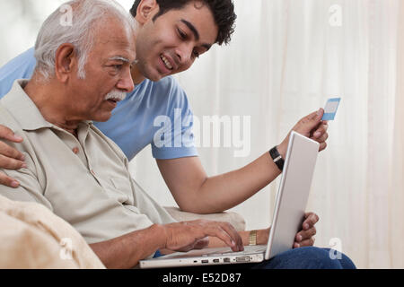 Nipote nonno di insegnamento come funziona il computer portatile Foto Stock