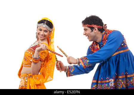 Indian matura in usura tradizionale eseguendo Raas Dandiya su sfondo bianco Foto Stock