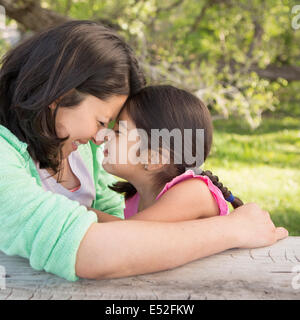 Una madre nel parco con sua figlia, ridendo e baciando ogni altro. Foto Stock