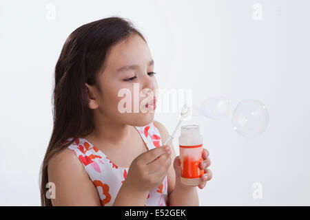 Bambina soffiare bolle Foto Stock