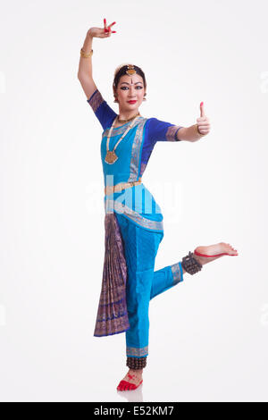 A piena lunghezza Ritratto di fiducioso giovane donna eseguendo Bharatanatyam su sfondo bianco Foto Stock