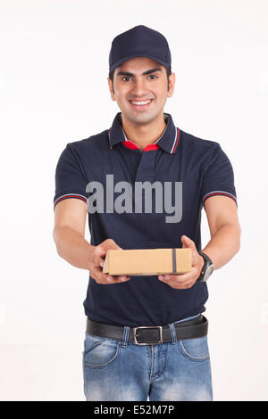 Ritratto di fiducioso uomo consegna pacchetto dando contro uno sfondo bianco Foto Stock