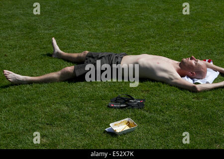 Westminster, Londra. Il 18 luglio 2014. Un uomo sunbathes sotto il caldo sole sulla banca del sud come londinesi swelter dall'ondata di caldo e il clima caldo nella capitale Credito: amer ghazzal/Alamy Live News Foto Stock