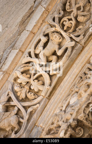 Dettaglio di un uomo con un oca sul romanico scolpito surround per le porte del XII secolo cattedrale romanica a Tran Foto Stock