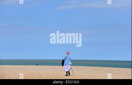 Aldeburgh Suffolk REGNO UNITO 15 Luglio 2014 - Viste intorno il Suffolk t cittadina balneare di Aldeburgh Lady di camminare sulla spiaggia con un bastone Foto Stock