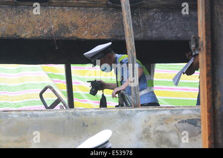 Shaoyang. 19 Luglio, 2014. Gli ufficiali di polizia lavorano presso il sito di un incidente di traffico su una sezione del Hukun (Shanghai a Kunming) Expressway nel centro di provincia cinese di Hunan, luglio 19, 2014. Almeno 38 persone sono morti accertati e un altro cinque feriti dopo uno scontro del veicolo attivato di incendio e di esplosione sull'autostrada Inizio del sabato mattina, la polizia ha detto. Credito: Xinhua/Alamy Live News Foto Stock