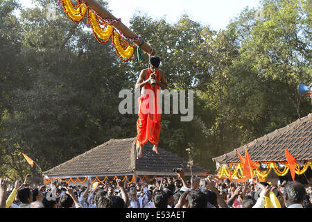 La devota Hindu trafitto da ganci acuti e sollevato dal suolo su una impalcatura utilizzando corde. Konkan, Maharashtra, India Foto Stock