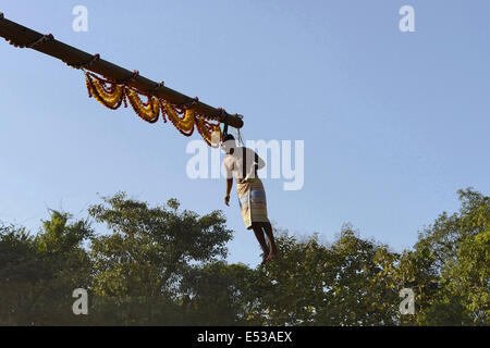 La devota Hindu trafitto da ganci acuti e sollevato dal suolo su una impalcatura utilizzando corde. Konkan, Maharashtra, India Foto Stock