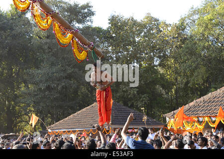 La devota Hindu trafitto da ganci acuti e sollevato dal suolo su una impalcatura utilizzando corde. Konkan, Maharashtra, India Foto Stock