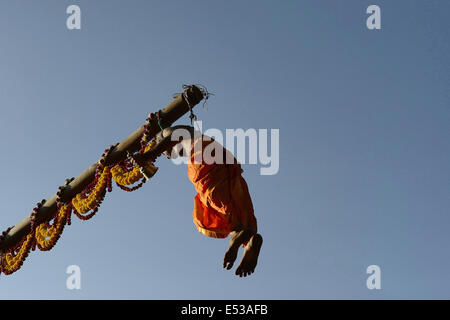 La devota Hindu trafitto da ganci acuti e sollevato dal suolo su una impalcatura utilizzando corde. Foto Stock